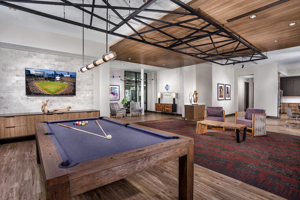 a living room with a pool table and a tv