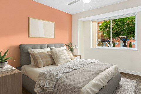 a bedroom with an orange wall and a bed with pillows