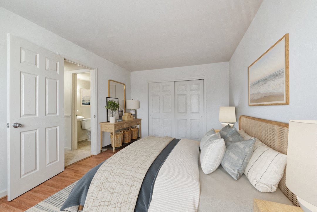 A bedroom with a large bed and a painting on the wall.
