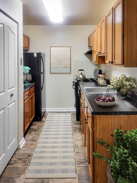 a kitchen with black appliances and wooden cabinets