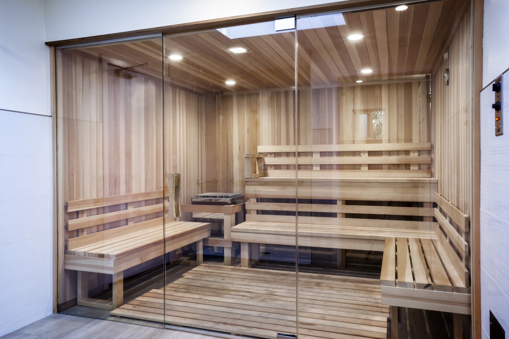 a sauna room with wooden benches and a glass door