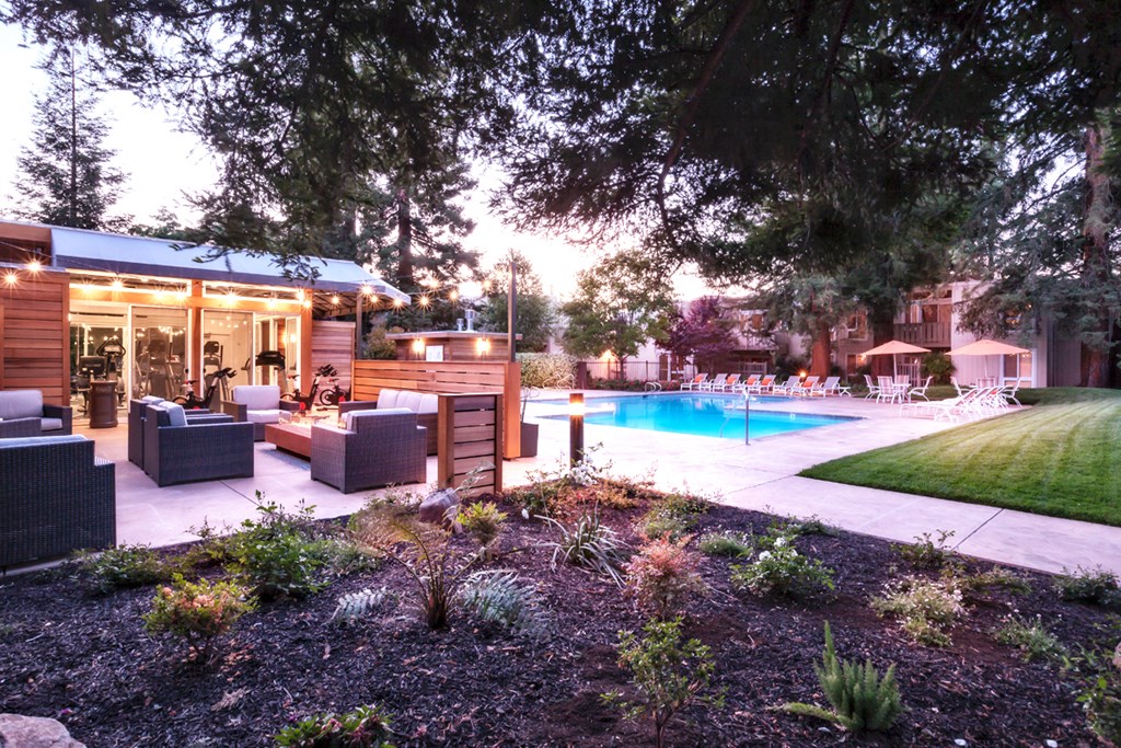 a backyard with a swimming pool and patio furniture