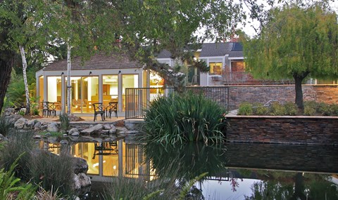 A house with a pond in front of it.