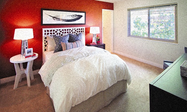 a bedroom with a bed and a red wall