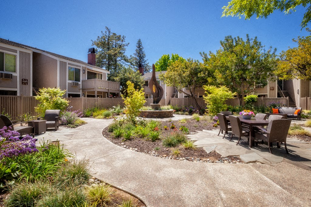 a patio with a table and chairs in a courtyard