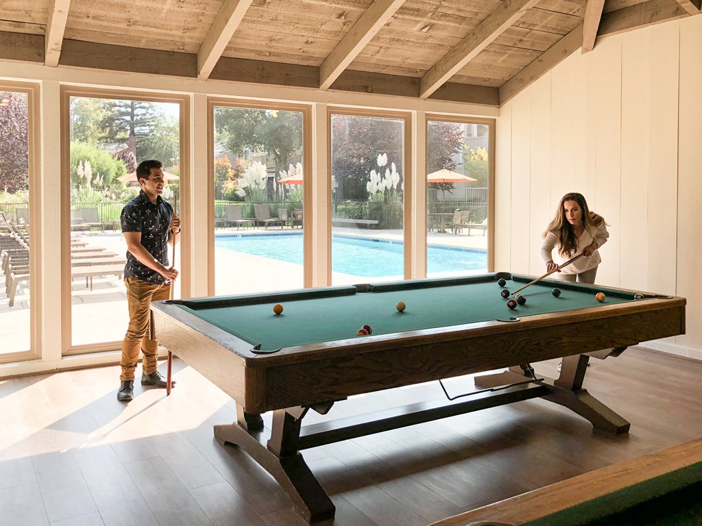 a man and woman playing a game of pool on a pool table