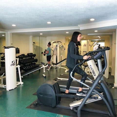 A person is using a treadmill in a gym.