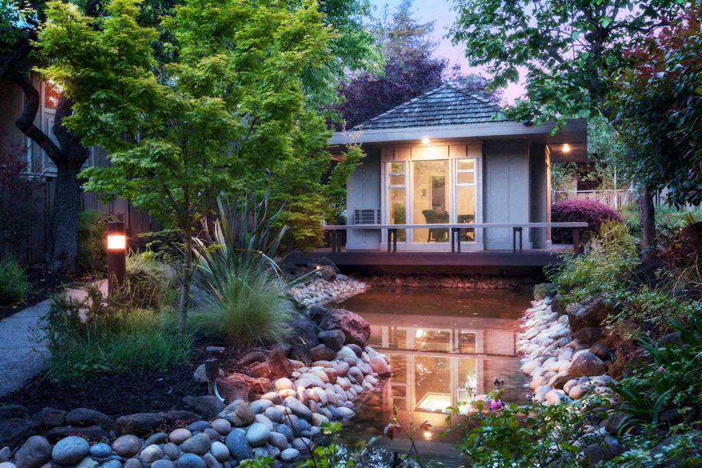 a house with a pond and a porch with lights