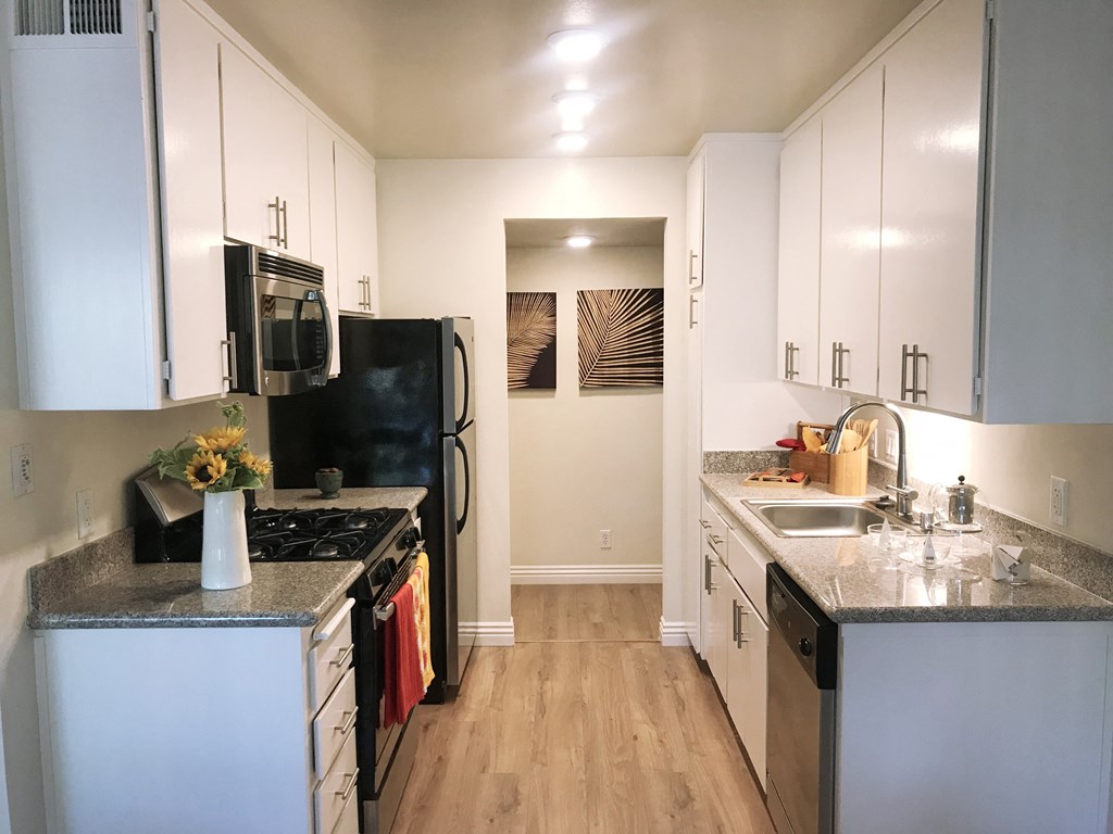 a renovated kitchen with white cabinets and stainless steel appliances