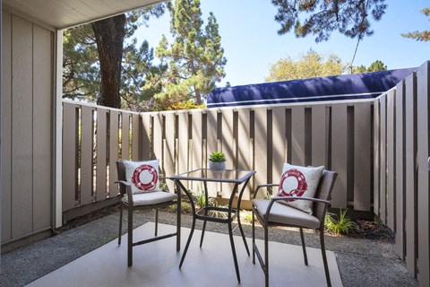 a patio with two chairs and a table on a patio