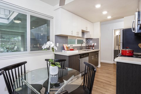 a kitchen and dining room with a glass table and chairs