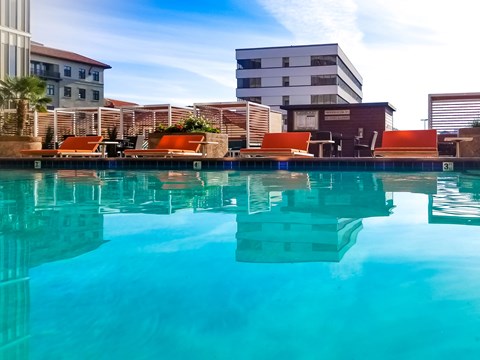 A pool with a reflection of the buildings around it.