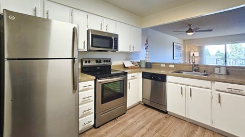A modern kitchen with stainless steel appliances and white cabinets.