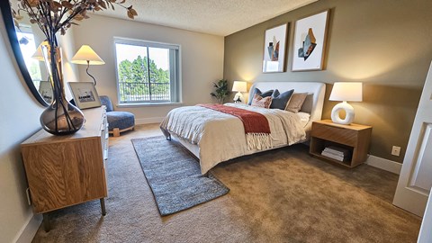 A bedroom with a large bed and a window.