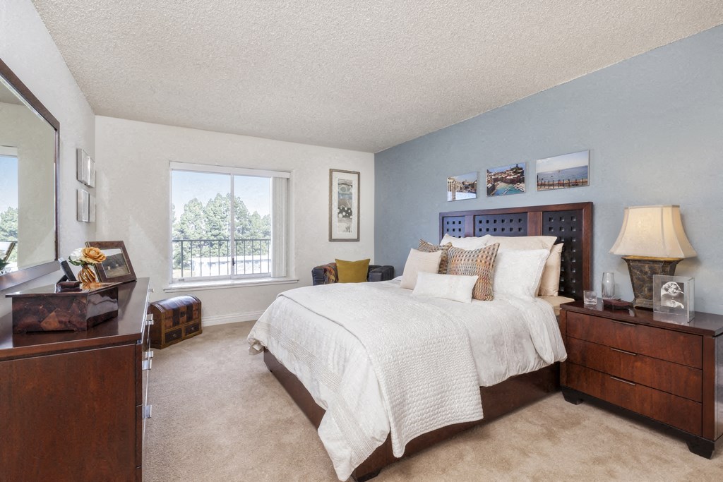 a bedroom with a bed and a dresser and a window