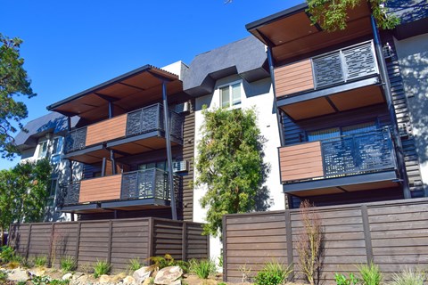 A modern house with a balcony and a fence.