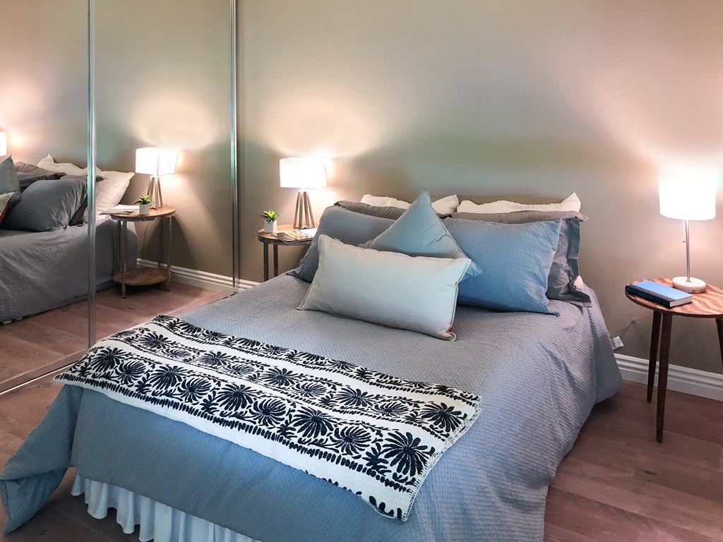 a bedroom with a bed with blue and white pillows