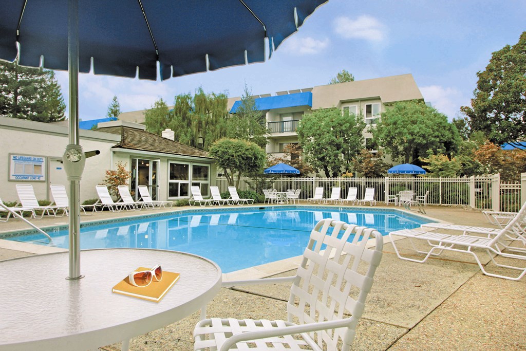 a swimming pool with chairs and a table