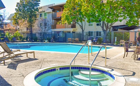 A small pool with a hot tub in the middle of it.