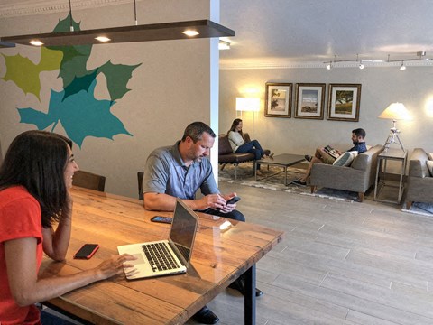 a man and woman sitting at a table with a laptop