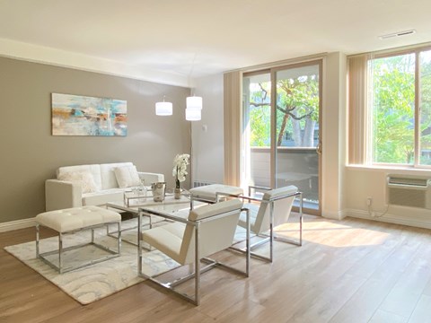 A modern living room with a glass table and white couch.