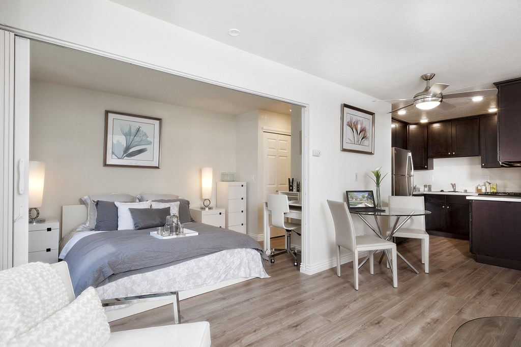 a bedroom with a bed and a desk and a living room