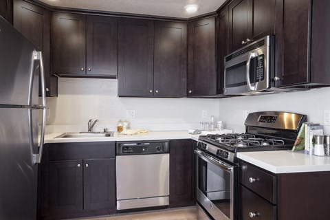 a kitchen with stainless steel appliances and dark wood cabinets