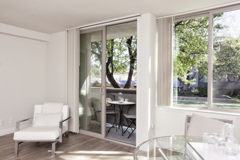 a living room with sliding glass doors and a table and chairs