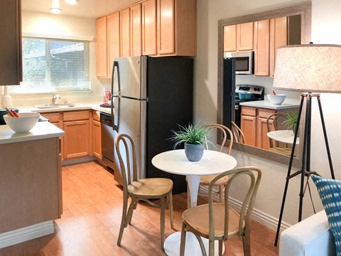 a kitchen with a small table and a refrigerator