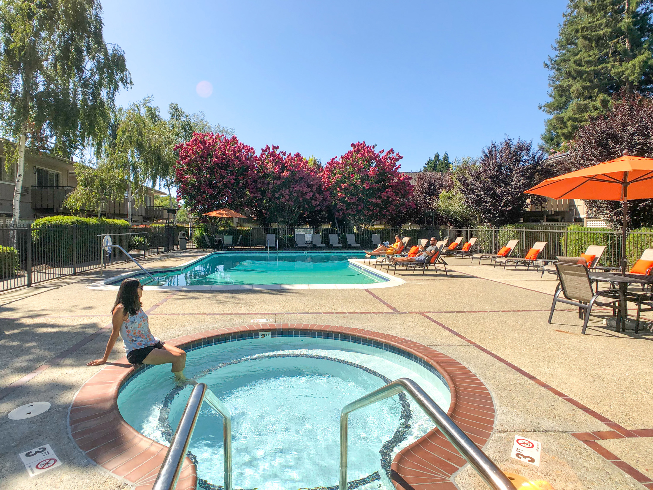 A woman is sitting on the edge of a small pool.