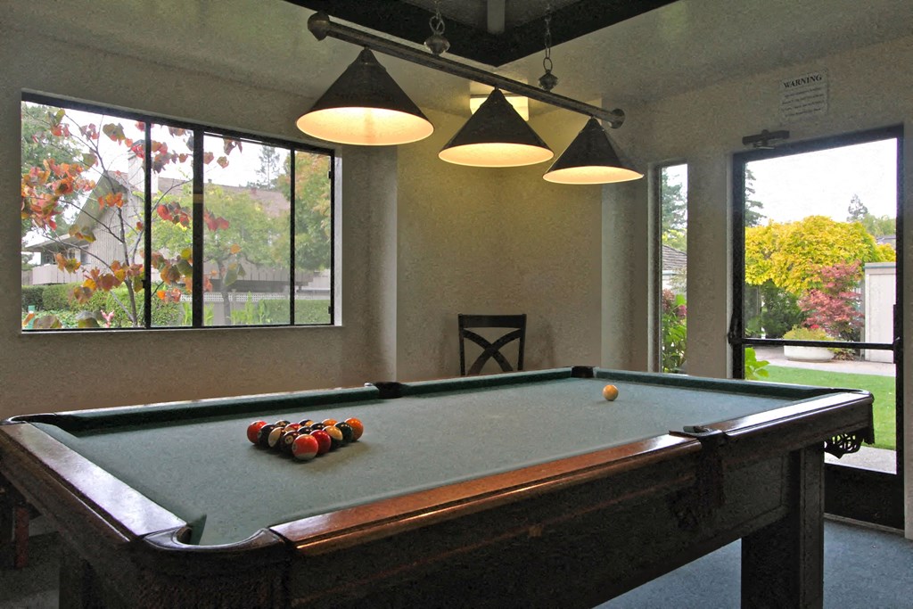 a pool table in a game room with three lights