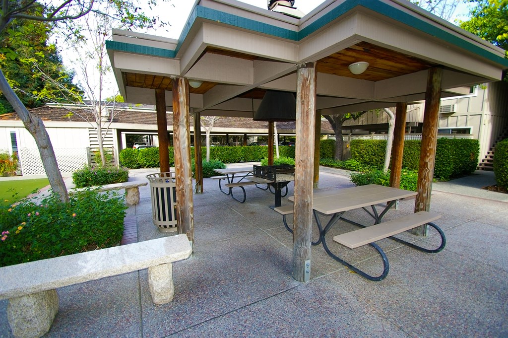 a pavilion with benches and tables in a courtyard