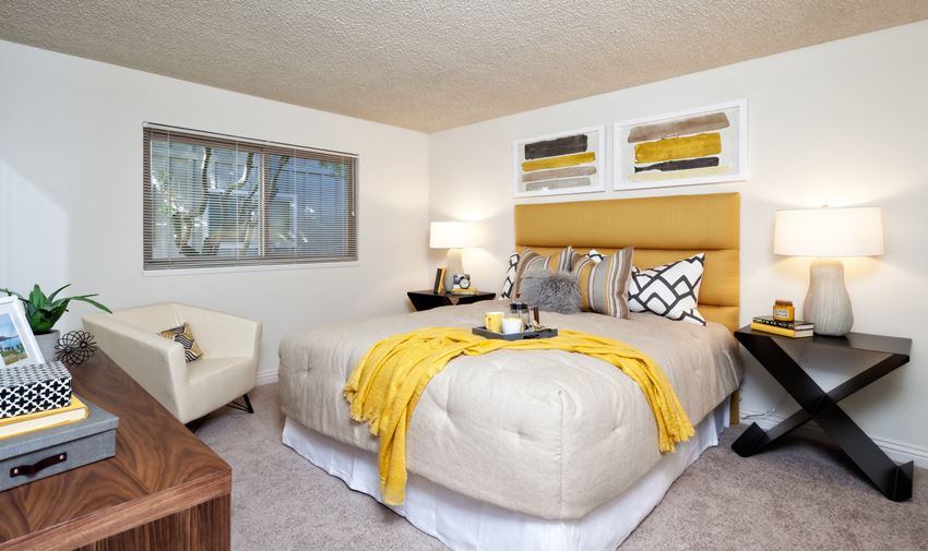 a bedroom with a large bed and a yellow blanket