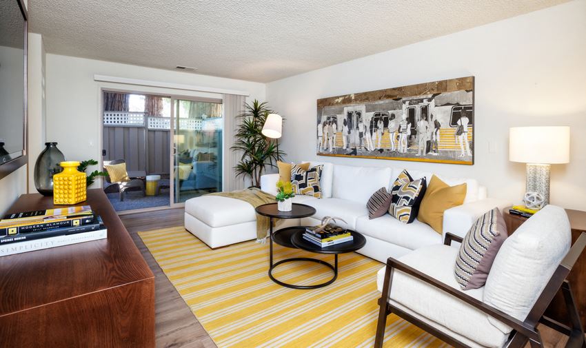 a living room with a yellow striped rug and a white couch