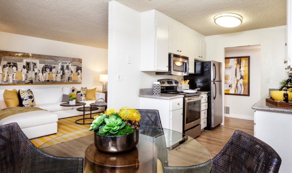 a living room and kitchen with a glass table