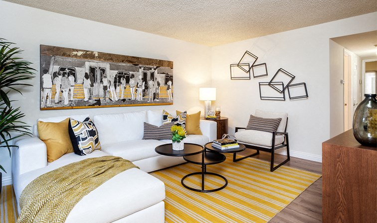 a living room with a white couch and a yellow rug