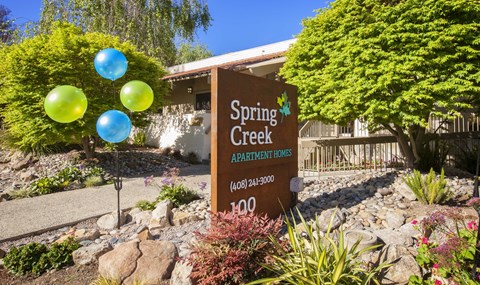 a sign apartments in front of a yard with balloons
