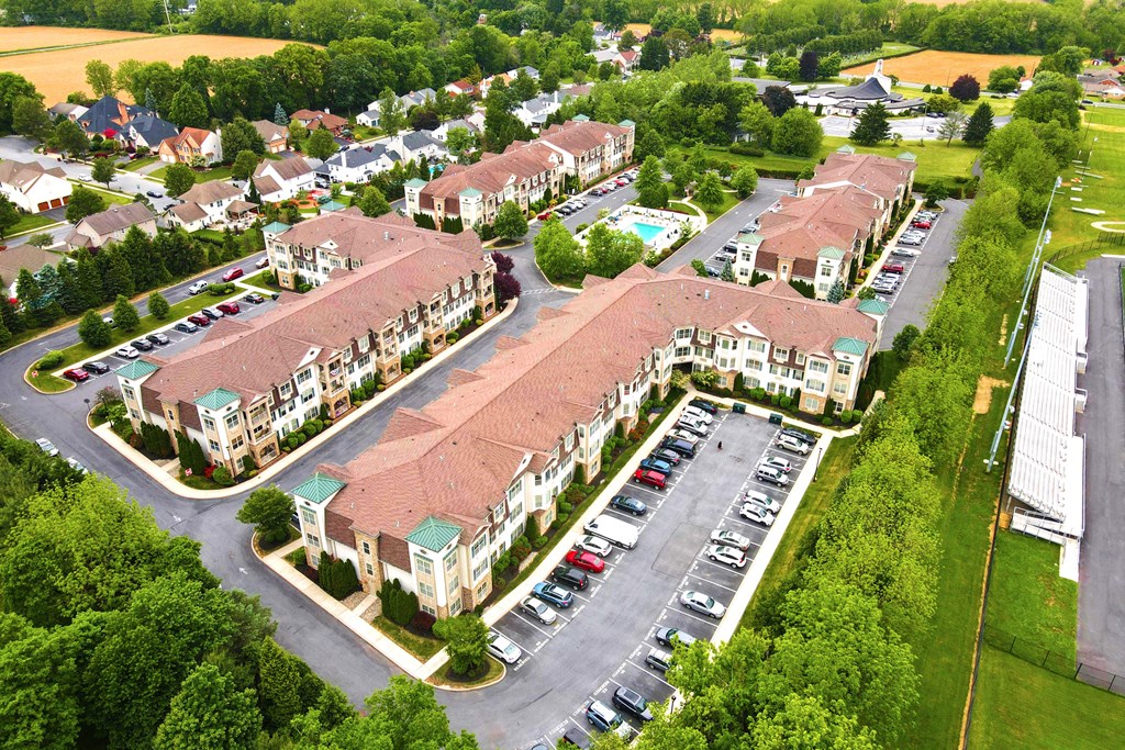 an aerial view of an apartment complex with cars parked in a parking lot
