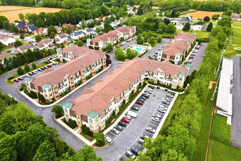 an aerial view of an apartment complex with cars parked in a parking lot