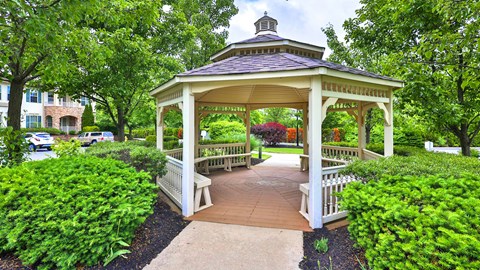 a gazebo in the middle of a park with benches