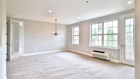 an empty living room with a window and a radiator