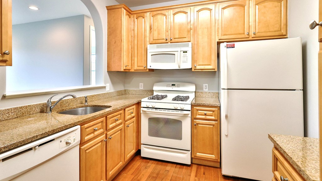 a kitchen with white appliances and wooden cabinets