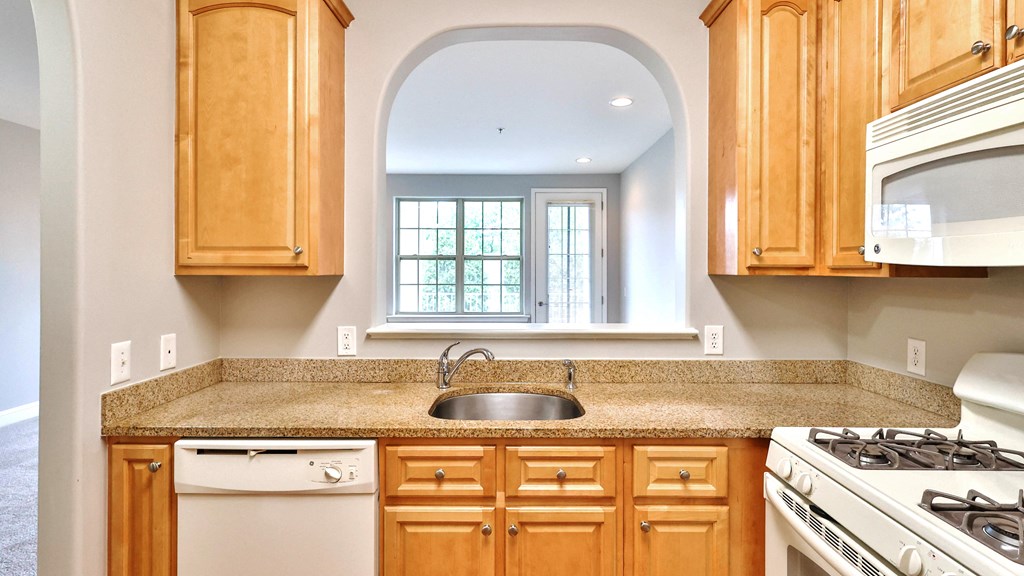 a kitchen with wooden cabinets and a granite counter top