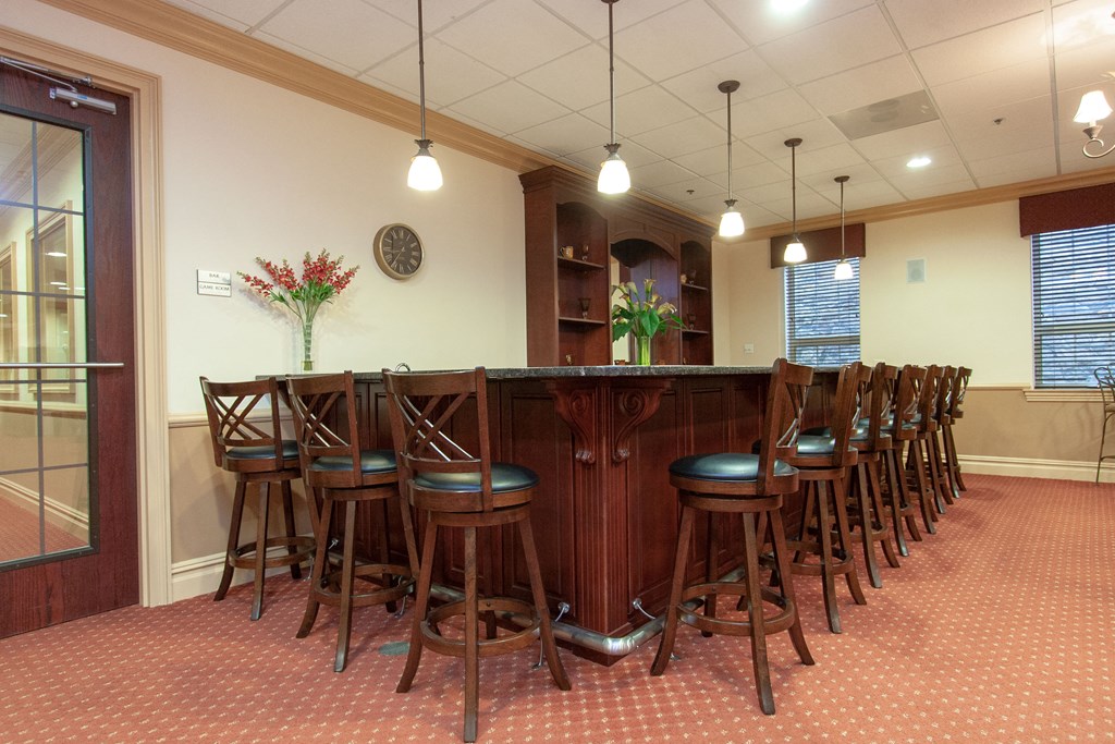 a dining room with a long bar and chairs