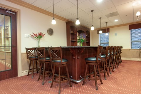 a dining room with a long bar and chairs