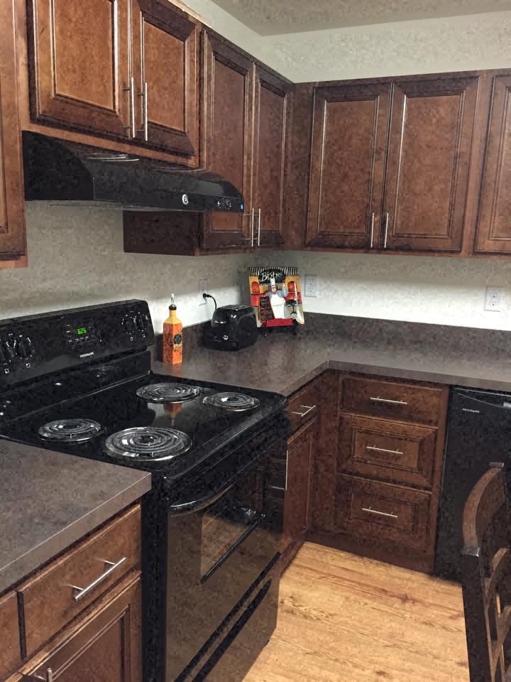 a kitchen with wooden cabinets and a black stove