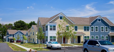 a row of houses with cars parked in front of them