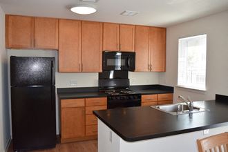 a kitchen with black appliances and wooden cabinets