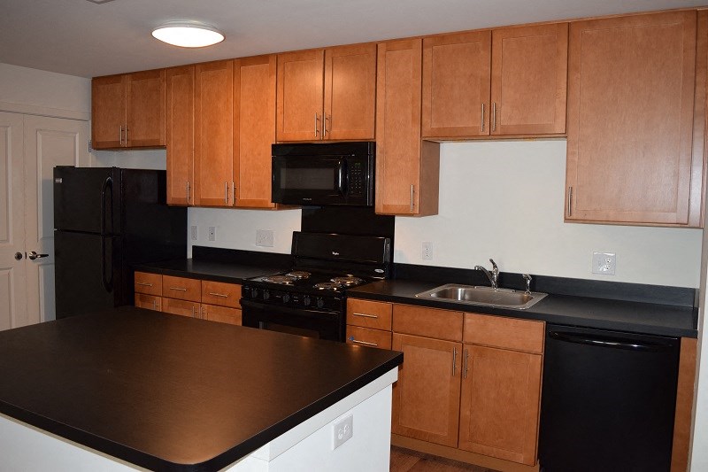 a kitchen with black appliances and wooden cabinets