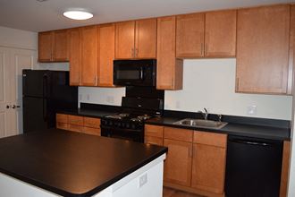 a kitchen with black appliances and wooden cabinets